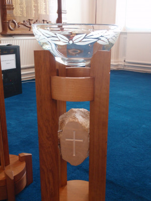 Contemporary timber and glass font with Gibralter rock carving